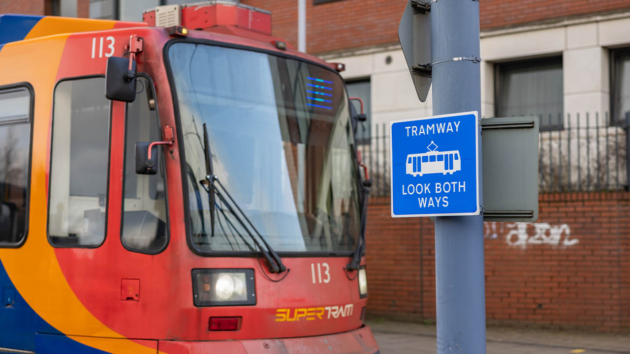 Warning sign saying Tramway look both ways at a tramline crossing