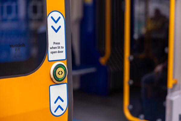 Photo of a tram door with a door open button