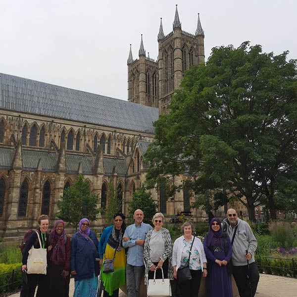 Eight members of the rail group stood facing the camera in front of Lincoln Cathedral