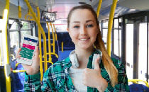 Female student holding a mobile phone up on a bus