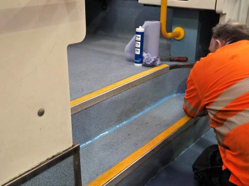 A team of two carefully removing overhead panels and signage to clear built-up dust and dirt