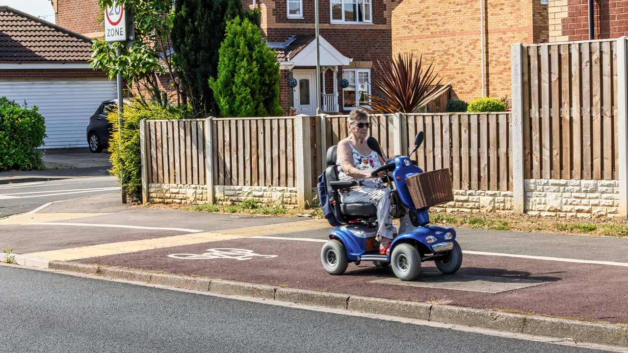 Lady riding mobile scooter on bike lane