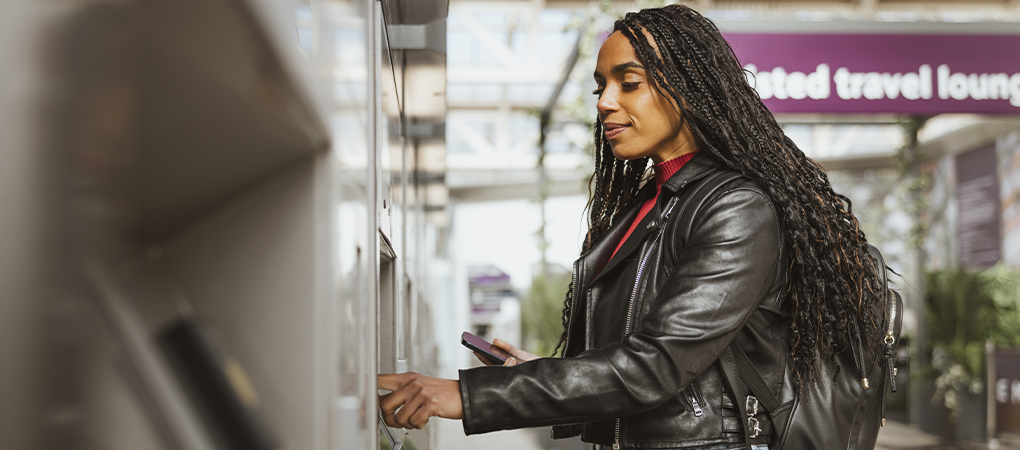 A lady getting bus ticket from a ticket vending machine at a bus internchange