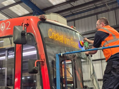 A team polishing and buffing the tram exterior to restore shine and presentation