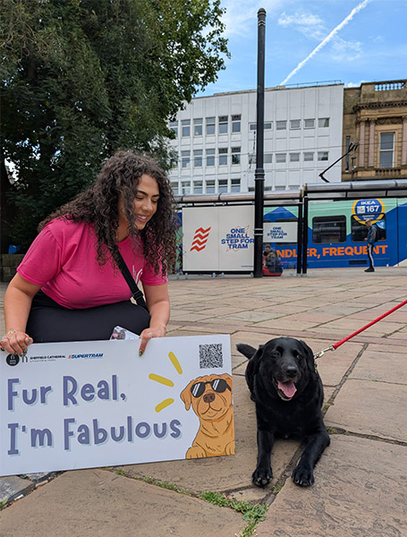 A lady with Fur Real, I'm fabulous sign with a dog