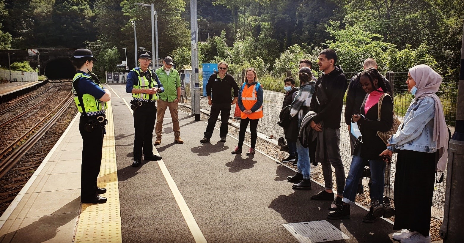 Police talking to people on a station platform